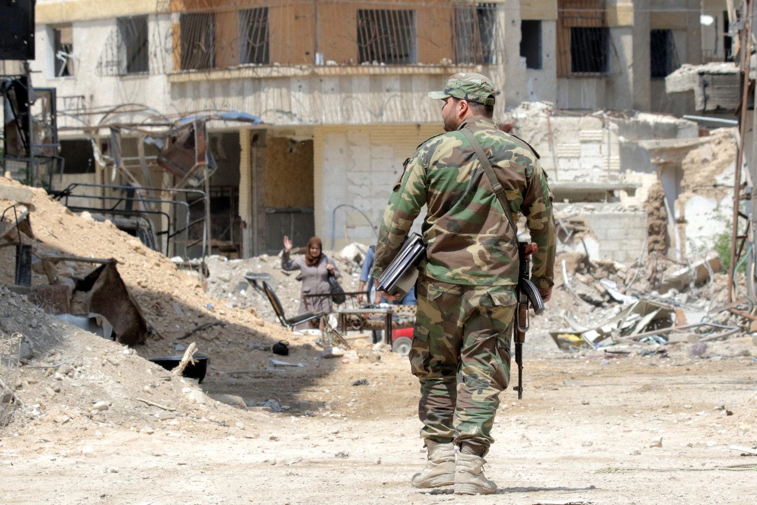A Syrian soldier walks amid destroyed buildings April 11 in the war-torn town of Ghouta. Lebanese Cardinal Bechara Rai appealed to world leaders to stop the war in Syria and to work for comprehensive peace through diplomatic means.